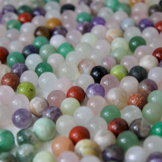 A mix of small, round crystal spheres in various colours and patterns.