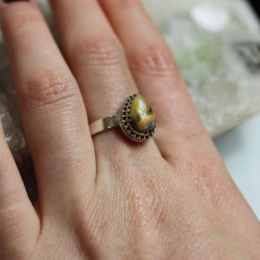 Bumblebee Jasper Sterling Silver Ring on a hand, resting on a crystal cluster.