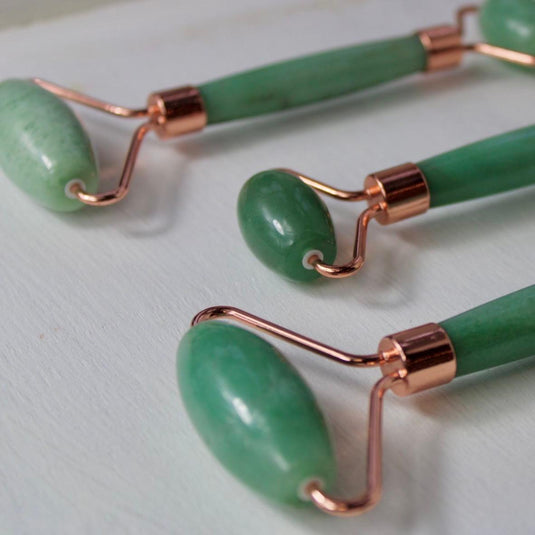 Three green aventurine massage rollers with rose gold handles