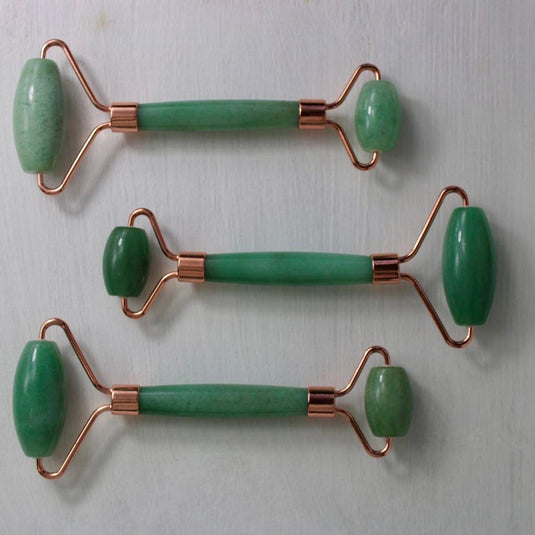 Three green aventurine massage rollers with rose gold handles