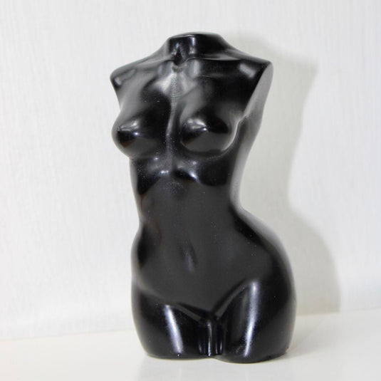 A sleek, black obsidian sculpture depicting a stylized female torso.