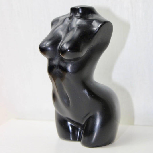 A sleek, black obsidian sculpture depicting a stylized female torso.