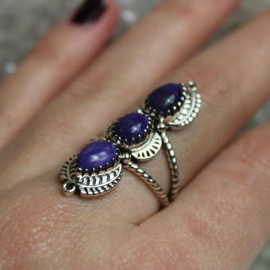 Admire the beauty of this charoite ring, featuring three captivating purple gemstones.