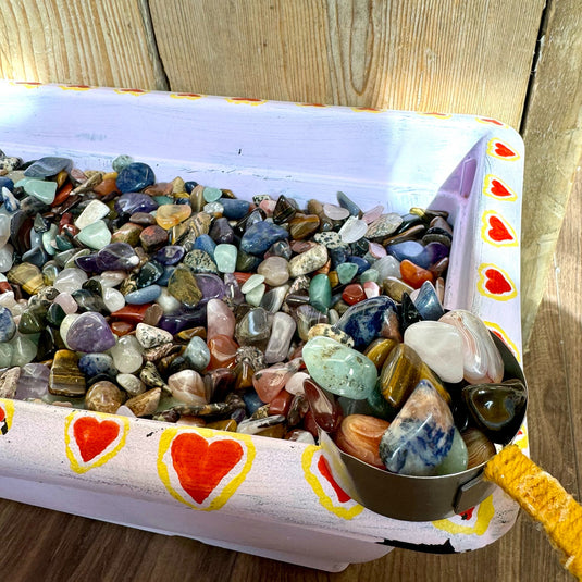 A container filled with crystal confetti, featuring a variety of colourful tumbled stones available at Keshet Crystals in Petersfield