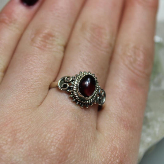 A vibrant red garnet stone set in a silver ring.