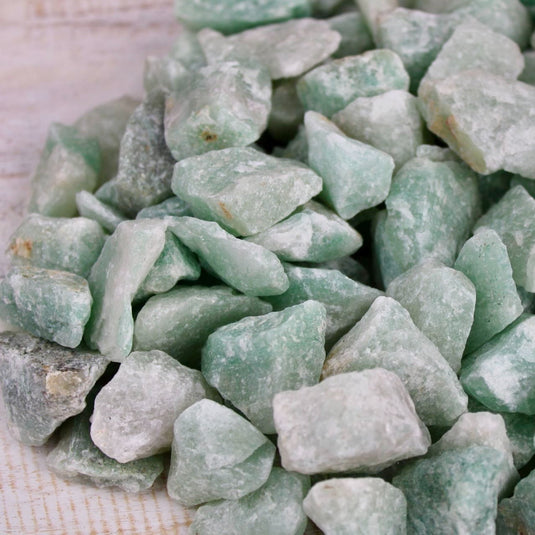 A close-up of raw green Aventurine stones.