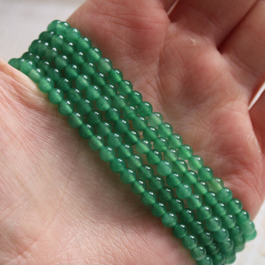 Green Aventurine Crystal 4mm Bead Bracelets Displayed Stacked in a Hand