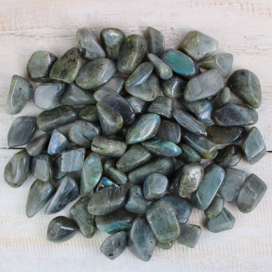 Labradorite Tumblestones on a white wooden background, available to purchase in store & online at Keshet Crystals