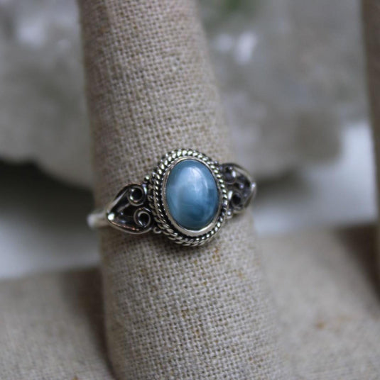 Close-up of a Larimar ring on a ring stand, highlighting the unique blue colour of the gemstone.