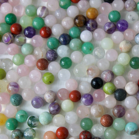 A variety of small, round crystal spheres in various colours and patterns.