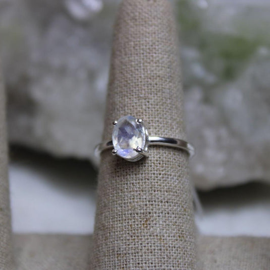 A prong setting moonstone sterling silver ring on a ring stand