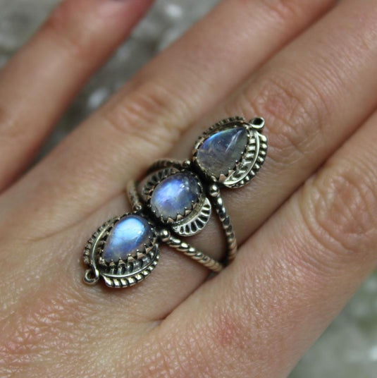 Sterling silver ring with three tear drop-shaped moonstone gemstones, each with a unique adularescence