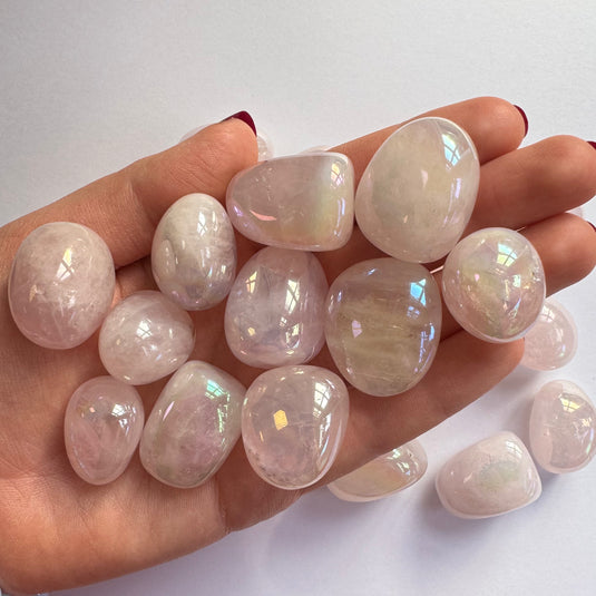 Aura Rose Quartz Tumblestones on a White Background in Hand