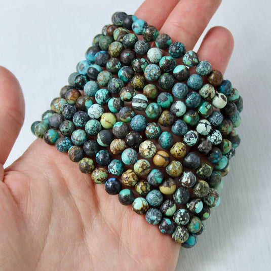 A stack of Chinese Turquoise beads, known for their grounding and protective properties.