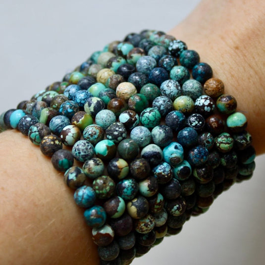 A stack of bracelets made with Chinese Turquoise beads, showcasing the stone's unique blue and green hues.